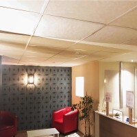 Salle d'attente avec un faux plafond en dalles acoustiques couleur sable