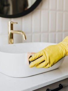 Nettoyage d'un lavabo avec une éponge