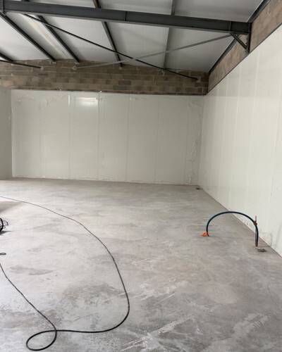Travaux d'installation de panneaux sandwich dans un entrepôt