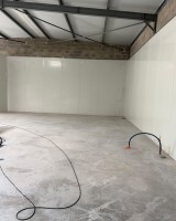 Travaux d'installation de panneaux sandwich dans un entrepôt