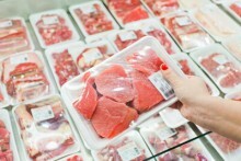 Personne montrant de la viande emballée dans un supermarché