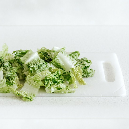 Salade découpée sur une planche à découper en polyéthylène