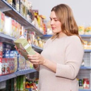 Femme lisant l'étiquette d'un produit dans  un supermarché