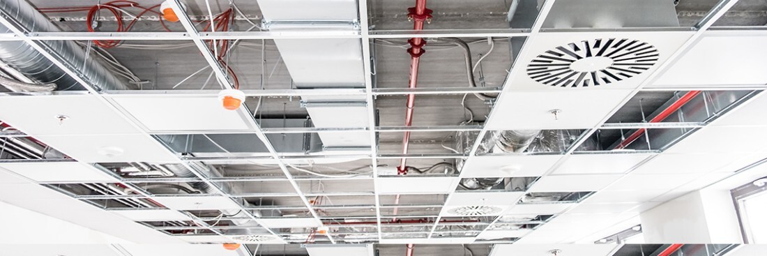 Faux plafond suspendu en cours d'installation avec vue sur les gaines techniques